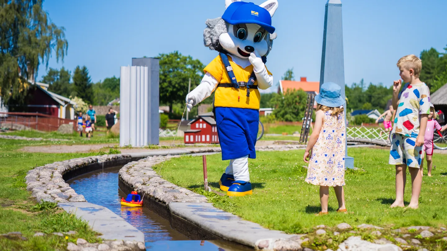 Grynet grävling och barn leker i minikanalen