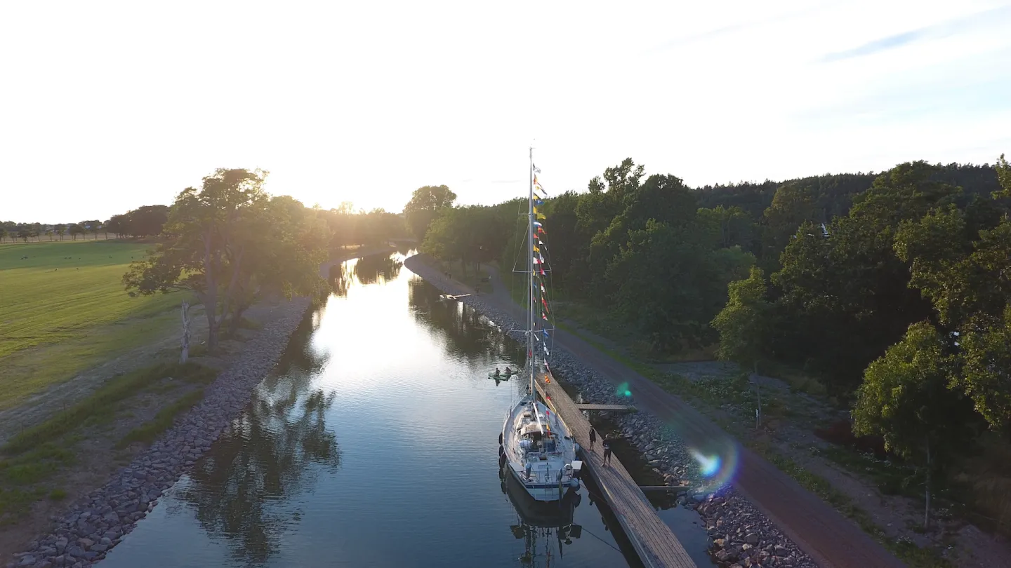 Segelbåt vid brygga i solnedgång