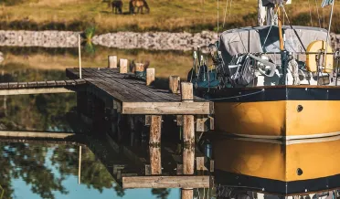 Båt ligger vid väntbrygga i Göta kanal