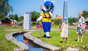 Grynet grävling och barn leker i minikanalen