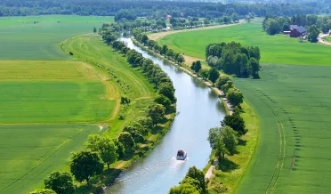 Fritidsbåt glider genom trädallén Göta kanal