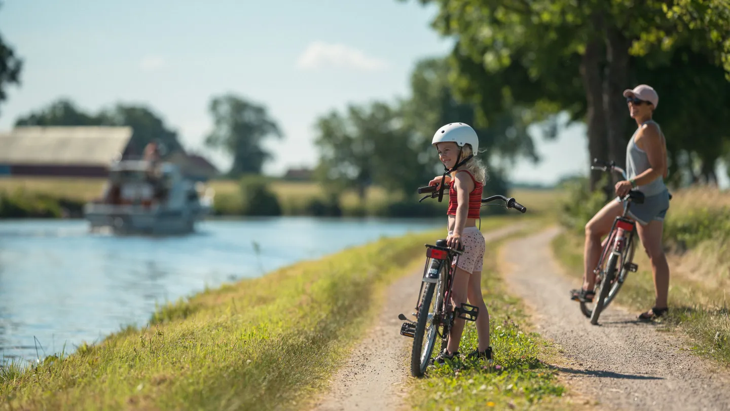 Två personer har stannat sina cyklar vid Göta kanal