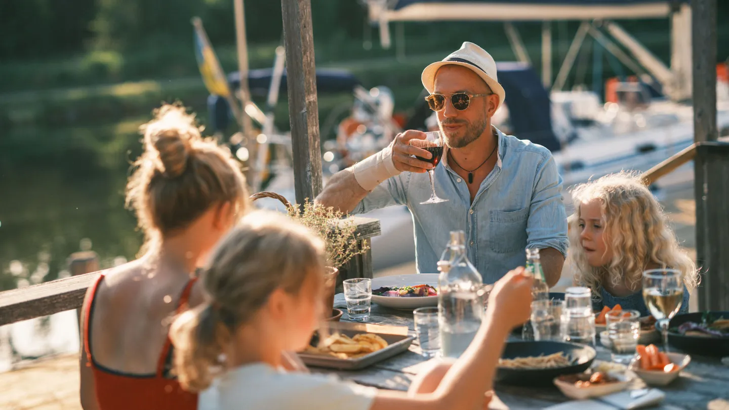 Familj äter lunch på bryggan